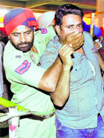 A policeman gags a protester during the SAD conference in Talwandi Sabo on Thursday