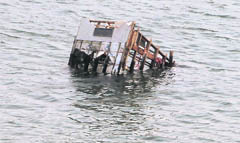 A damaged house is seen floating in sea in an area devastated by the March 11 earthquake and tsunami, in Ofunato, Iwate prefecture,