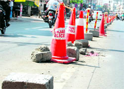Broken slabs, which support the dividers, on Lawrence Road pose a threat to commuters