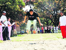 A girl participates in the long-jump event at the annual sports meet of SGRR College in Dehradun on Friday.
