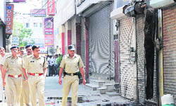 The SP, Hamid Ansari (second from right), along with a police force at the furniture market where a shop was set on fire in Karnal 