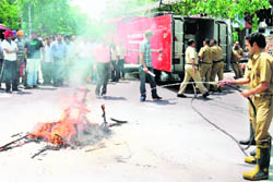 A fireman douses a flame during a mock drill at Shastri Market in Sector 22, Chandigarh, on Saturday