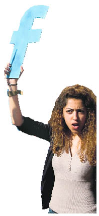 A young protester holds an f in recognition of Facebook's role in the North African revolts, during a protest in Rabat in March, 2011