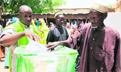 A Nigerian man casts his vote at a polling station during the presidential elections in Daura. Nigerians turned out in large numbers to vote