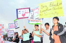 Young children hold placards depicting social messages during a mini-marathon organised by Selaqui School in Dehradun on Sunday