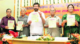 Uttarakhand Parliamentary Affairs and Water Resources Minister (centre) releases a souvenir at a function of the Uttarakhand Lok Bhasha Sammelan, in Dehradun on Sunday.