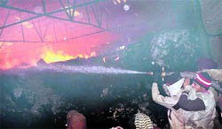 Firefighters extinguish the flames at a cotton factory in Samana