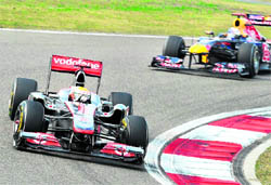 McLaren-Mercedes Lewis Hamilton (L) is chased by Red Bull-Renaults Sebastian Vettel during the Formula One Chinese Grand Prix in Shanghai on Sunday. Hamilton won the race