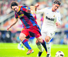 Barcelona's Lionel Messi (L) vies with Real Madrid's Sergio Ramos in Madrid, on Saturday