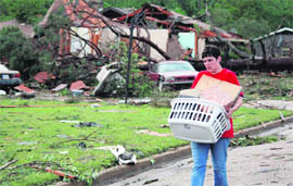 A woman salvages personal items after a tornado caused widespread damage in east Clinton on Friday.