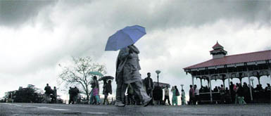 People try to escape the rain in Shimla on Monday.
