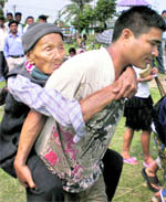 An elderly woman being carried to a polling booth.