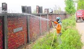 A labourer waters the under-construction boundary wall of IIT-Ropar