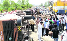 Onlookers at the site on the Panchkula-Parwanoo road where three persons were killed in a collision between a tipper and a motorcycle (below) near Surajpur on Tuesday.