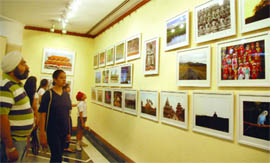 People admiring pictures at a photography exhibition, Glimpses of Asia', by Dr Peeyush Jain, at India Habitat Centre, in New Delhi 