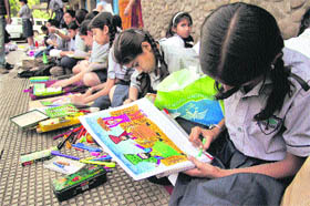 Children take part in a painting competition at the Abhinav Theatre in Jammu on Tuesday.