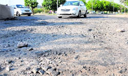 A bumpy ride greets vehicles due to potholes on the road near the rotary of Sectors 33 and 34 in Chandigarh