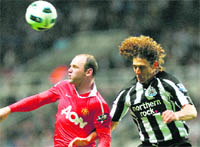 Manchester United's Wayne Rooney (L) and Newcastle Uniteds Fabricio Coloccini jump for the ball at St James' Park 