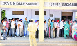 Voters wait for their turn to cast vote during the 3rd phase of the panchayat elections in the Upper Gadigarh area in Jammu on Thursday