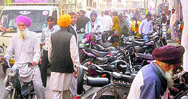 Vehicles parked haphazardly outside a bank on the Lajpat road in Jagraon.