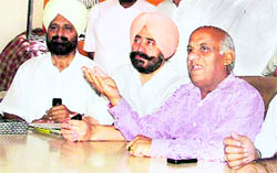 District Congress Committee president Jagmohan Sharma (in pink shirt) addresses a press conference against the implication of the MC Zonal Commissioner in a corruption case in Ludhiana on Thursday.