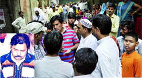 Relatives and neighbours of Ram Gopal Verma (inset), shot by robbers, gather outside his residence at Shastri Park in east Delhi on Friday.