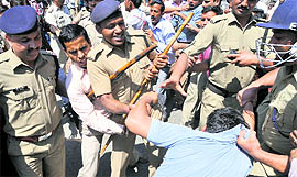 Policemen try to remove BEd/BPEd Berozgar Sangathan members who were blocking the Rajpur road in support of their demands in Dehradun on Friday.