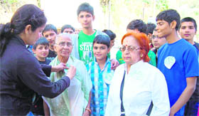 Students and staff members of Manav Bharti International School put badges on tourists in Mussoorie on Friday.