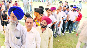 People wait for their turn to cast vote during the third phase of the panchayat poll in the lower Gadi Ghar area of Jammu.