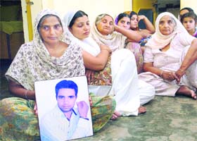 Grieving family members of Lakhwinder Singh with his picture at Raimajra village near Rajpura on Friday