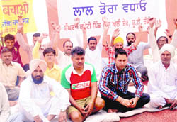 Residents of Khudda Alisher and their supporters sit on a dharna to protest