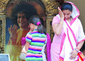 Devotees mourn the death of Sathya Sai Baba, in New Delhi on Sunday