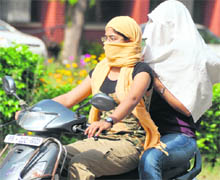 Girls mask their face with cloth to escape the scorching heat in Ludhiana on Sunday