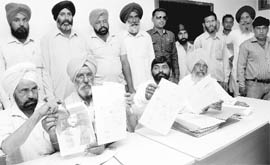 Landowners of Mullanpur and surrounding villages show documents forged by the property dealer in Mohali on Monday. A Tribune photograph