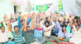 Members of the Jammu Kashmir Medical Employees Federation stage a protest in front of the Directorate of Health Services in Jammu on Monday. 