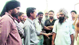 Truck drivers argue on the 'selective' unloading process by FCI employees at Dana Mandi, Gill Road.