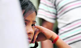 Kanchan, the daughter of Kamini, gives a blank look after her mother committed suicide in Ludhiana on Monday.