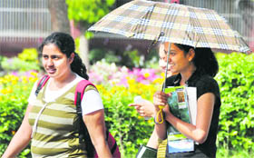 With the mercury rising, a girl guards herself from the scorching heat in Ludhiana on Monday.
