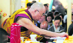 The Dalai Lama joins prayers at the main temple in McLeodganj on Tuesday