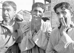 Relatives of two policemen killed by militants wail during a wreath-laying ceremony in Srinagar on Tuesday