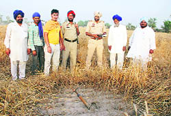 Police officials and farmers at the site where the IAF rocket between Tappar and Ramghar Bhullar villages on Tuesday.