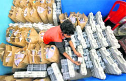 A worker checks tags on electronic voting machines (EVM) meant for use in the third phase of Assembly elections, in Kolkata on Tuesday