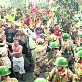 Soldiers try to disperse anti-government protesters during a demonstration demanding the ouster of Yemen's President in Taiz on Tuesday