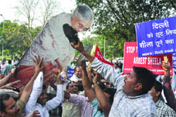 BJP members and NGO activists beat a cut-out of Chief Minister Sheila Dikshit with a slipper during a protest demanding her arrest for the Commonwealth Games corruption, outside the CMs residence in New Delhi on Wednesday