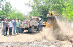 A JCB machine removes earth for the construction of an underpass in Aggar Nagar, Ludhiana, on Wednesday