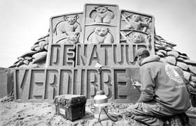 A man finishes his sand sculpture on the beach in Scheveningen, Netherlands, on Wednesday during the 20th Sandsculpture Festival which takes place every year. This year's theme is 'Give the earth'