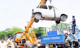 A JCB removes an illegally parked car from municipal land during an anti-encroachment drive at the Sector 48 Motor Market in Chandigarh on Thursday.