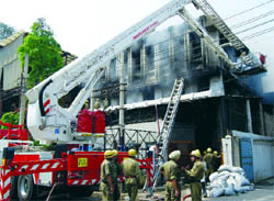 Delhi fire personnel douse the flame at a shoe factory in the Peeragarhi area of northwest Delhi on Thursday