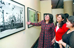 Corporate lawyer-cum-photographer Khushi Mishra (extreme left) shows her picture 'Birds all over Jama Masjid' to some visitors at India Habitat Centre in New Delhi