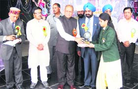 Chief Minister PK Dhumal gives a prize to a student at Green Hills Engineering College at Gandhi Gram near Kumarhatti on Thursday